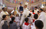 Latin Patriarch of Jerusalem Pierbattista Pizzaballa (C) poses for a picture with people and children at the Holy Family Church in the Zeitoun neighbourhood of Gaza City on December 22, 2024. (Omar Al-Qattaa/AFP)