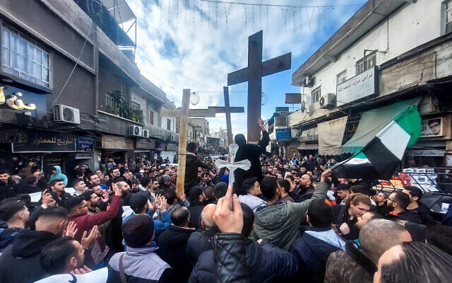 Christian Syrians lift crosses as they rally in the Duweilaah area of Damascus on December 24, 2024, to protest the burning of a Christmas tree near Hama in central Syria. (Louai Beshara / AFP) Christian Syrians lift crosses as they rally in the Duweilaah area of Damascus on December 24, 2024, to protest the burning of a Christmas tree near Hama in central Syria. (Louai Beshara / AFP)
