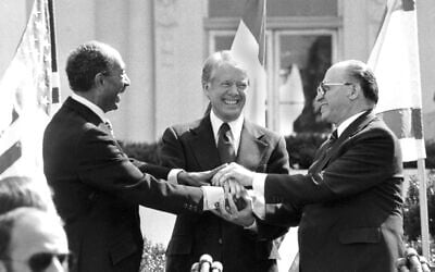 Egyptian president Anwar Sadat, left, US president Jimmy Carter, center, and Israeli prime minister Menachem Begin clasp hands on the north lawn of the White House after signing the peace treaty between Egypt and Israel on March 26, 1979. (AP/ Bob Daugherty)