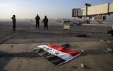 A Syrian official flag lies on the ground as opposition fighters stand on the tarmac of the Aleppo international airport in Aleppo, December 2. (AP Photo/Omar Albam)