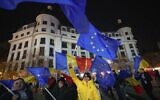 People wave Romanian and European Union flags during a pro-European rally in Bucharest, Romania, December 5, 2024. (AP Photo/Andreea Alexandru)