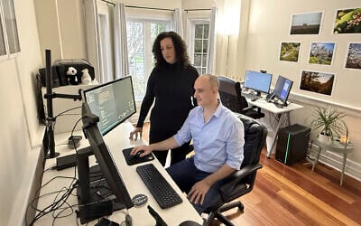 Michal Harel, left, and her husband show the website they set up to help Israelis navigate a move to Canada, in Oakville, Ontario, Canada, December 4, 2024. (AP Photo/Rob Gillies)