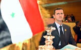 File: Then-Syrian president Bashar al-Assad looks on at his country's flag at the opening of the 16th ordinary session of Arab Summit in Tunis, Tunisia, May 22, 2004. (AP Photo/Amr Nabil)