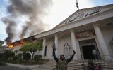 Opposition fighters celebrate as they burn down a military court in Damascus, Syria, Sunday, December 8, 2024. (AP Photo/Hussein Malla)