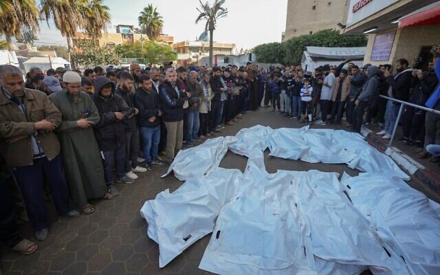 Palestinians pray over the bodies of people killed in an Israeli army strike against Hamas in the Nuseirat refugee camp, at the Al-Aqsa Martyrs hospital in Deir al-Balah, Gaza Strip, December 12, 2024.  (Abdel Kareem Hana/AP)