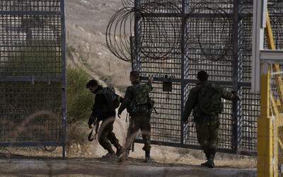 Israeli soldiers close the security fence gate near the so-called Alpha Line that separates the Golan Heights from Syria, in the town of Majdal Shams, Thursday, December 12, 2024. (AP/Matias Delacroix)