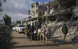 Palestinians carry UN-donated flour in Khan Younis, central Gaza Strip, Saturday December 14, 2024.(AP Photo/Abdel Kareem Hana)