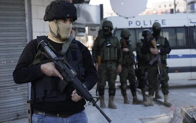 A Palestinian Authority security officer clutches his gun amid a major raid against members of terror groups in the Jenin refugee camp in the West Bank, December 16, 2024. (AP Photo/Majdi Mohammed)