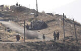 A Syrian man, left, waves a white flag as he approaches Israeli soldiers to speak to them at a position at an abandoned Syrian military base, in Maariyah village near the border with Israel, in southern Syria, Dec. 19, 2024. (AP/Hussein Malla)