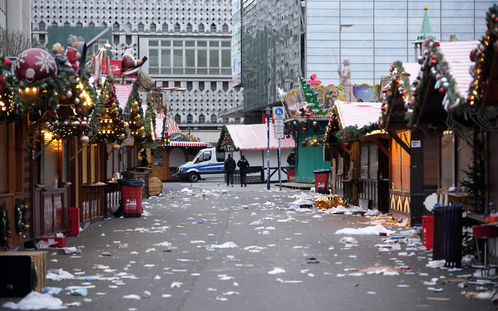 Police officers walk through a cordoned-off Christmas Market, where a car drove into a crowd in Magdeburg, Germany, December 21, 2024. (AP Photo/Ebrahim Noroozi)