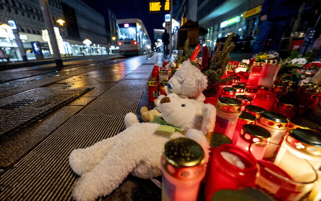Teddy bears were laid together with candles near the Christmas market, where a car drove into a crowd in Magdeburg, Germany,  Dec. 22, 2024. (AP Photo/Michael Probst)