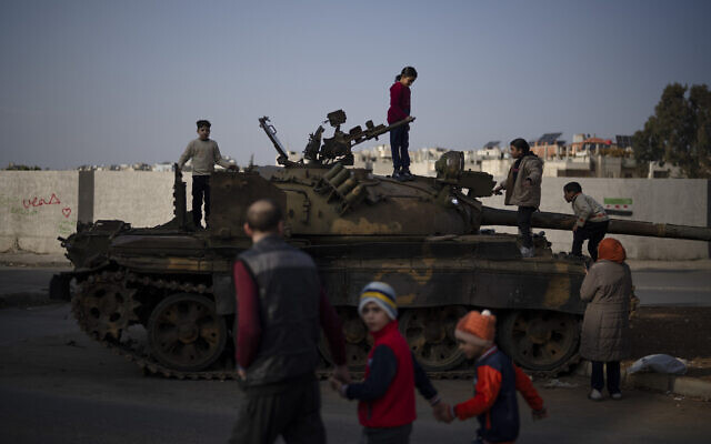 Children on the top of an ousted Syrian government forces tank that was left on a street in an Alawite neighborhood, in Homs, Syria, December 26, 2024. (AP Photo/ Leo Correa) Children on the top of an ousted Syrian government forces tank that was left on a street in an Alawite neighborhood, in Homs, Syria, December 26, 2024. (AP Photo/ Leo Correa)