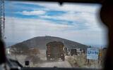 A convoy of IDF vehicles approach a United Nations position on the border between Israel and Syria in the Golan Heights on  December 11, 2024. The Syrian Army Tel Kwdana post can be seen in the background. (Emanuel Fabian/Times of Israel)