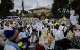 Families of Israelis held hostage in the Gaza Strip and their supporters dress in white as they attend a silent protest calling for the release of the hostage, outside the Knesset in Jerusalem, November 25, 2024. (Chaim Goldberg/Flash90)