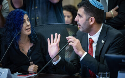 Kan 11 music editor Michal Assulin argues with Communications Minister Shlomo Karhi during an emergency conference on freedom of expression in the Knesset, December 4, 2024. (Yonatan Sindel/Flash90)