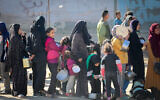 Palestinians line up for food in Deir Balah, Gaza, on December 25, 2024. (Ali Hassan/Flash90)