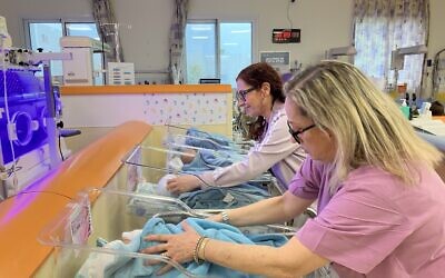 Debbie Cohen, head nurse of Nursery Department A, and Amira Morad, staff nurse, check on newborn babies at Galilee Medical Center on December 22, 2024. (Diana Bletter/Times of Israel)