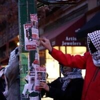 Keffiyeh-clad individuals slash and rip down posters of October 7 hostages hung in New York, as seen in Nim Shapira's film 'TORN: The Israel-Palestine Poster War on NYC Streets.' (Courtesy)