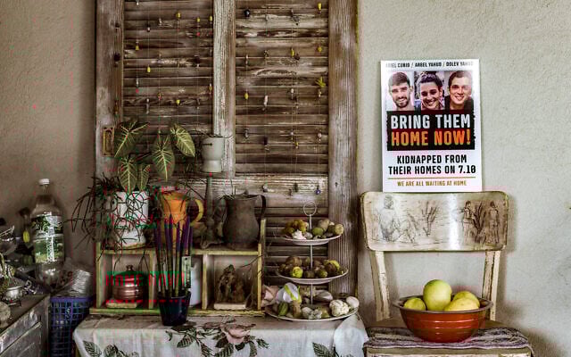A poster showing the portraits of Arbel Yehoud (C), her brother Dolev Yehoud (R), and her partner Ariel Cunio (L) at their father's home in Rishon LeZion in central Israel on December 8, 2023 (MARCO LONGARI / AFP)