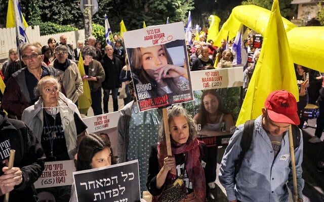 Protesters stand with portraits of Israeli hostages Agam Berger (20), Naama Levy (20), and others during a demonstration calling for the release of hostages kidnapped to Gaza by Hamas October 7, 2023 attacks, outside the Prime Minister's residence in Jerusalem, October 24, 2024. (Ahmad Gharbli/AFP)