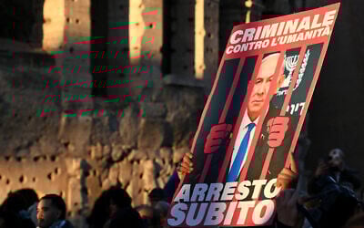 A demonstrator holds up a placard with Prime Minister Netanyahu behind bars and the Italian words "criminal against humanity, lets arrest him now," during an anti-Israel rally in support of Palestinians in Rome on November 30, 2024. (Alberto Pizzoli/AFP)