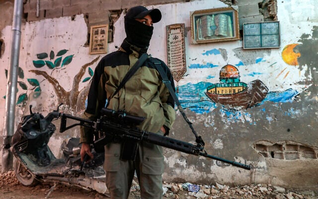 A Palestinian gunman stands guard with an assault rifle along an alley in the Jenin refugee camp in the northern West Bank on December 29, 2024.(Jaafar Ashtiyeh/AFP) A Palestinian gunman stands guard with an assault rifle along an alley in the Jenin refugee camp in the northern West Bank on December 29, 2024.(Jaafar Ashtiyeh/AFP)