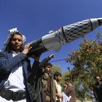 A man carries a mock missile during a rally by university students and faculty denouncing strikes on Yemen and in solidarity with Palestinians, in the Houthi-controlled capital Sanaa on January 1, 2025. (Mohammed HUWAIS / AFP)