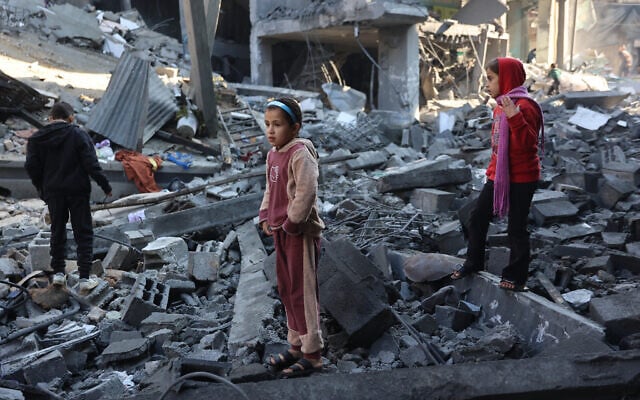 Palestinian children inspect the damage at the site of an Israeli strike the previous night, in Jabalia, in the central Gaza Strip on January 1, 202. (Omar AL-QATTAA / AFP)