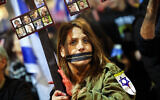 A protester with her hands bound and mouth taped shut holds a placard during a demonstration calling for the release of hostages held captive in Gaza by Hamas terrorists since the October 7 attacks, outside the Defense Ministry headquarters in Tel Aviv on January 4, 2025. (Jack Guez / AFP)