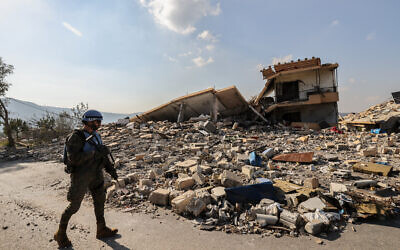 A member of the Spanish UNIFIL peacekeepers forces stands in front of the rubble of  destroyed buildings during a patrol in the southern Lebanese village of Borj El Mlouk, near the border with Israel, on January 7, 2025, amid a fragile truce between Israel and Hezbollah. (Anwar Amro / AFP)