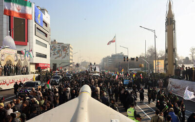 Members of Iranian paramilitary forces (Basij) march next to a Iranian long range Sejil missile, during an anti-Israel rally in Tehran, January 10, 2025. (AFP)