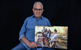 Holocaust survivor Naftali Furst holds a family photo taken in Israel, as he poses in his home in the northern Israeli city of Haifa, on November 28, 2024. (MENAHEM KAHANA / AFP)