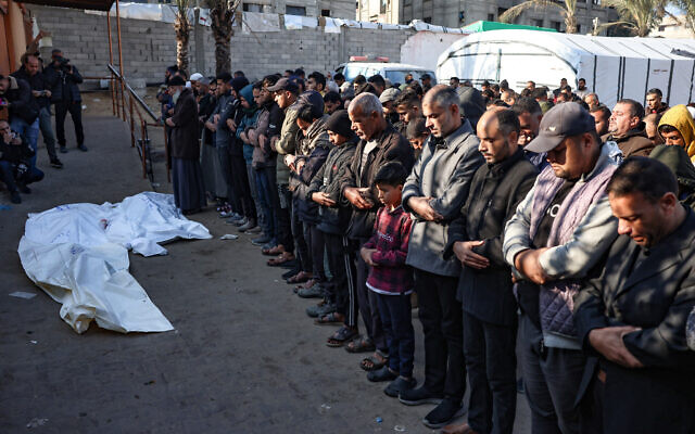 Mourners recite a prayer over the bodies of four people killed in an Israeli strike north of Khan Yunis in the southern Gaza Strip, in the yard of the Nasser hospital on January 18, 2025 (Photo by BASHAR TALEB / AFP)