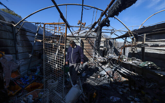 A Palestinian man inspects the damage at his shop on January 21, 2025, after it was burnt in overnight Israeli settler attacks in Jinsafut village in the West Bank. (Photo by JAAFAR ASHTIYEH / AFP)