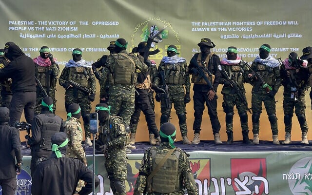 Hamas fighters gather on an apparently purpose-built stage at a square before handing over four Israeli hostages to the Red Cross in Gaza City on January 25, 2025 (AFP)