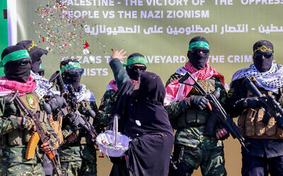 A Palestinian woman throws confetti as Hamas gunmen prepare to hand over four Israeli hostages to a Red Cross team from a stage at a square in Gaza City on January 25, 2025. (Omar AL-QATTAA / AFP)