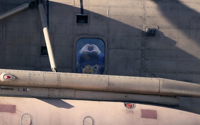 Newly released hostage Liri Albag gestures a heart shape with her hands, from the window of a military helicopter as it prepares to land at the Rabin Medical Centre in Petah Tikva on January 25, 2025 (JACK GUEZ / AFP)