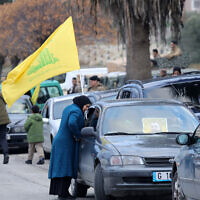 A resident of Kfar Kila carries a Hezbollah flag as people gather in Burj al-Muluk on January 26, 2025, behind an Israeli roadblock across a road leading to their village in southern Lebanon (Rabih DAHER / AFP)