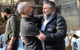 Ashraf Zughayer (L), a 46-year-old convicted Palestinian terrorist who spent 23 years in prison serving six life sentences and was released by Israel, is greeted by a well-wisher at his family home in Kafr Aqab in East Jerusalem on January 26, 2025. (Zain JAAFAR / AFP)