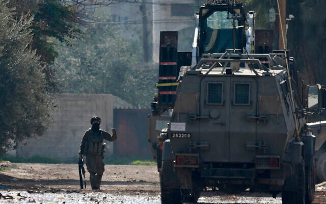 An IDF soldier gestures during a raid in Jenin in the West Bank on January 27, 2025. (Jaafar Ashtiyeh/AFP)