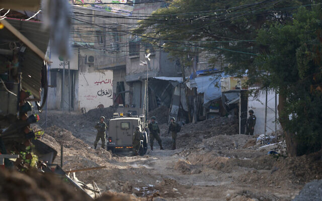 Israeli soldiers stand near their vehicle on a destroyed road as they conduct a raid in Tulkarem, the West Bank on January 28, 2025. (Jaafar ASHTIYEH / AFP) Israeli soldiers stand near their vehicle on a destroyed road as they conduct a raid in Tulkarem, the West Bank on January 28, 2025. (Jaafar ASHTIYEH / AFP)