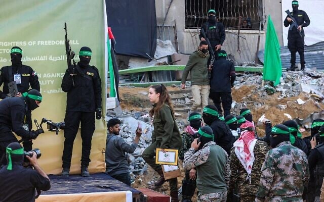 Hostage soldier Agam Berger is escorted onto a stage in northern Gaza's Jabalia, surrounded by Hamas gunmen, before she is handed over to the Red Cross on January 30, 2025 (Omar AL-QATTAA / AFP) Hostage soldier Agam Berger is escorted onto a stage in northern Gaza's Jabalia, surrounded by Hamas gunmen, before she is handed over to the Red Cross on January 30, 2025 (Omar AL-QATTAA / AFP)