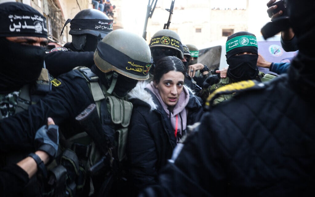 Palestinian terrorists surround Israeli hostage Arbel Yehoud to hand her over to a Red Cross team in Khan Younis on January 30, 2025. (Eyad BABA / AFP)