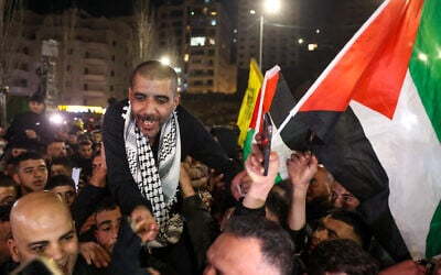 Zakaria Zubeidi, 49, a Palestinian prisoner and former a top commander in the Al-Aqsa Martyrs’ Brigades who was released by Israel, waves a Palestinian flag as he is cheered by people after arriving in Ramallah aboard buses of the International Committee of the Red Cross (ICRC), on January 30, 2025. (AHMAD GHARABLI / AFP)