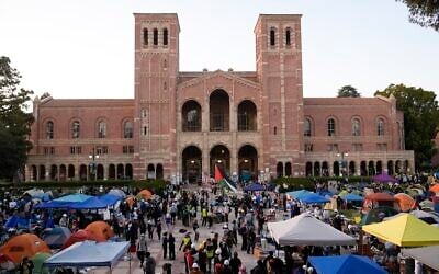 Demonstrators walk in an encampment on the UCLA campus after clashes between protestors demonstrating about the Israel-Hamas war, Wednesday, May 1, 2024, in Los Angeles. (AP Photo/Jae C. Hong, file)