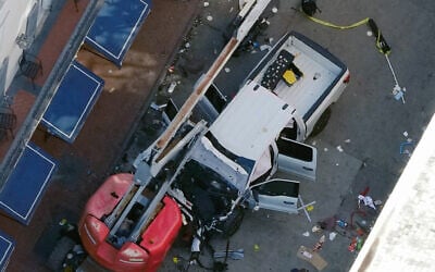 A black flag with white lettering lies on the ground rolled up behind a pickup truck that a man drove into a crowd on Bourbon Street in New Orleans, killing and injuring a number of people, early Wednesday morning, Jan. 1, 2025. (AP Photo/Gerald Herbert)
