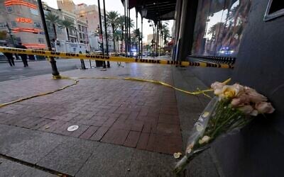 A bouquet of flowers stands at the intersection of Bourbon Street and Canal Street during the investigation after a pickup truck rammed into a crowd of revelers early on New Year's Day, January 1, 2025, in New Orleans. (AP Photo/Matthew Hinton)