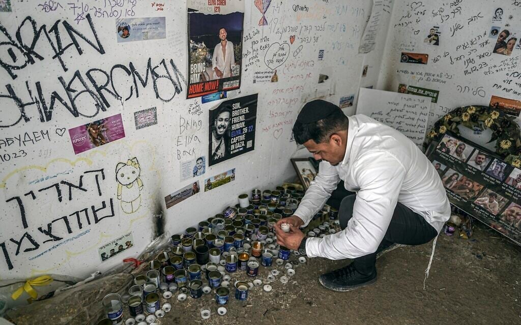 A man lights a candle at a memorial in a shelter where several people were killed by Hamas terrorists during the October 7, 2023 attack in southern Israel, near the Gaza border, Thursday, January 2, 2025. (AP Photo/Tsafrir Abayov)