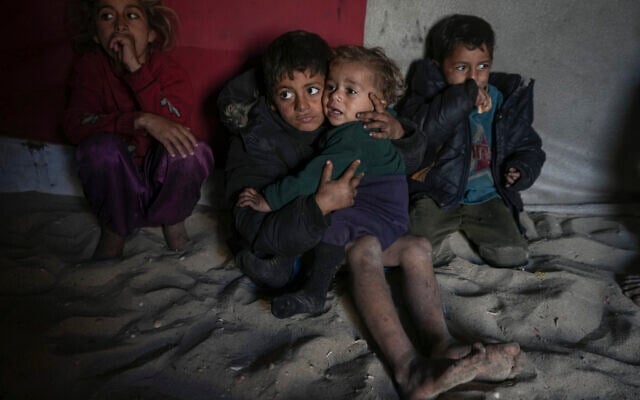 Palestinian Tamim Marouf, 6, sits inside his family's tent alongside his sister Hala, 10, and his brother Malek, 4, at a camp for internally displaced Palestinians on the beachfront in Deir al-Balah, central Gaza Strip, Friday, Dec. 27, 2024. (AP Photo/Abdel Kareem Hana)