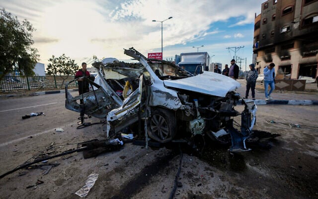 Palestinians inspect a car targeted in an overnight Israeli airstrike in Khan Younis, southern Gaza Strip, Jan. 4, 2025. (AP Photo/Abdel Kareem Hana)